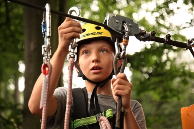 a child is in a rope harness in a tree