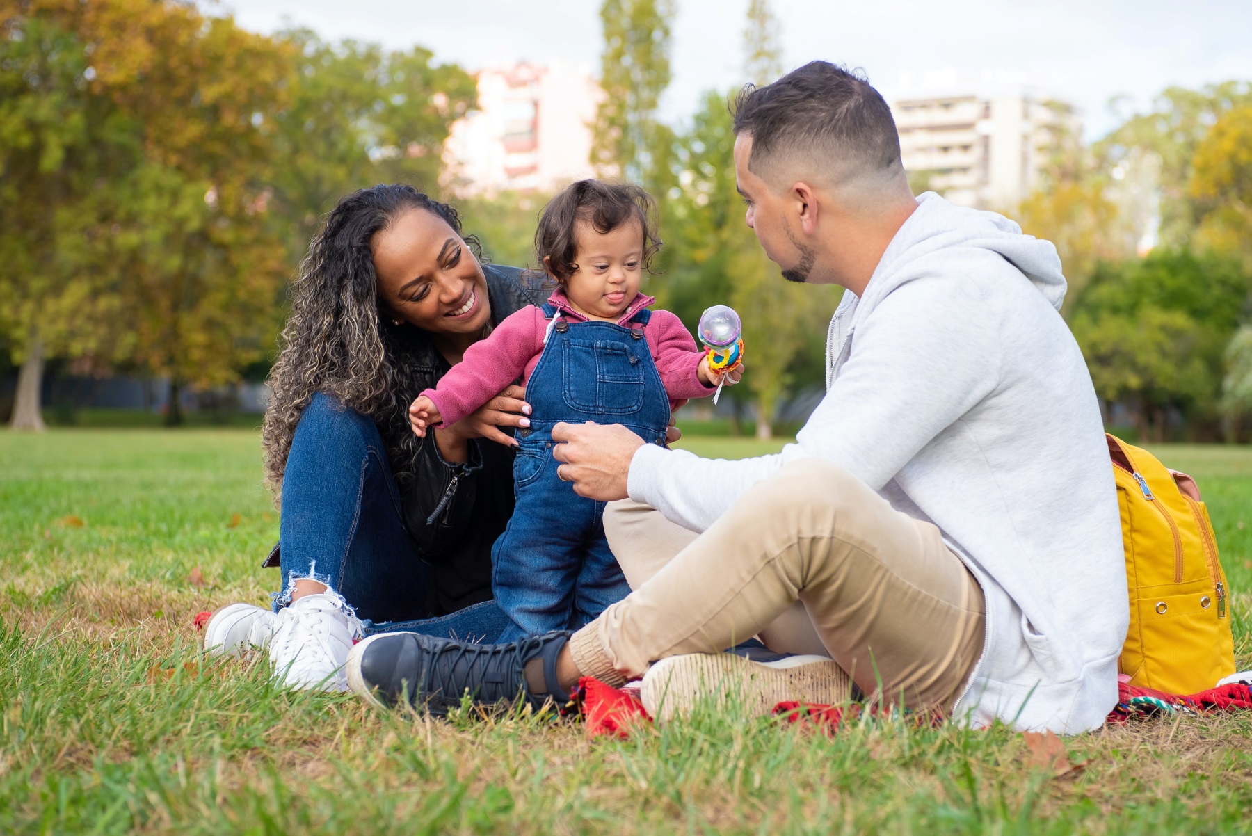 a child with SEND is playing with their parents in a park