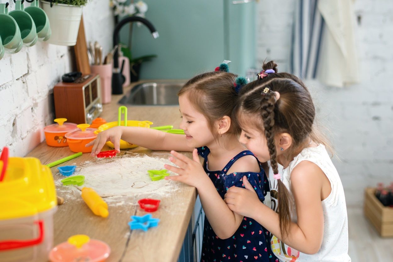 Two children are playing with flour on a worktop